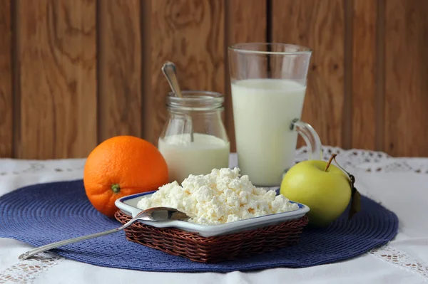 Prato de queijo de casa de campo, uma garrafa de leite e frutos . — Fotografia de Stock