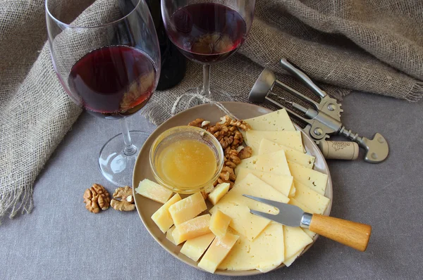 Dois copos de vinho e um prato de queijo . — Fotografia de Stock