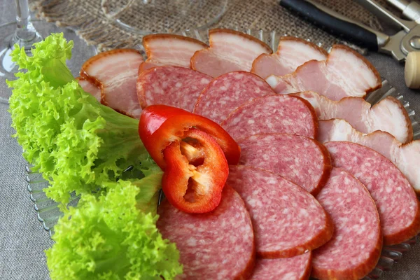 Plate of sausages, decorated with lettuce. — Stock Photo, Image