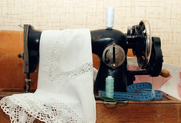 Old sewing machine, topped with a cloth. — Stock Photo, Image