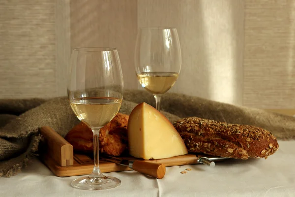Two glasses with white wine and cheese. — Stock Photo, Image