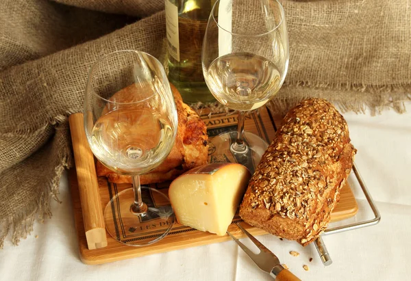 Två glas med vitt vin, hembakat bröd och ost. — Stockfoto