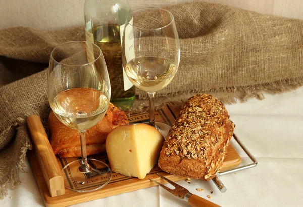 Två glas med vitt vin, hembakat bröd och ost. — Stockfoto