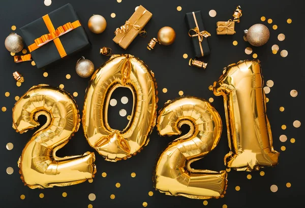 2021 balloon gold text on black background with golden confetti, Christmas gift boxes, gold balls, festive decor. Happy New year eve invitation with Christmas gold foil balloons 2021. Long web banner — Stock Photo, Image