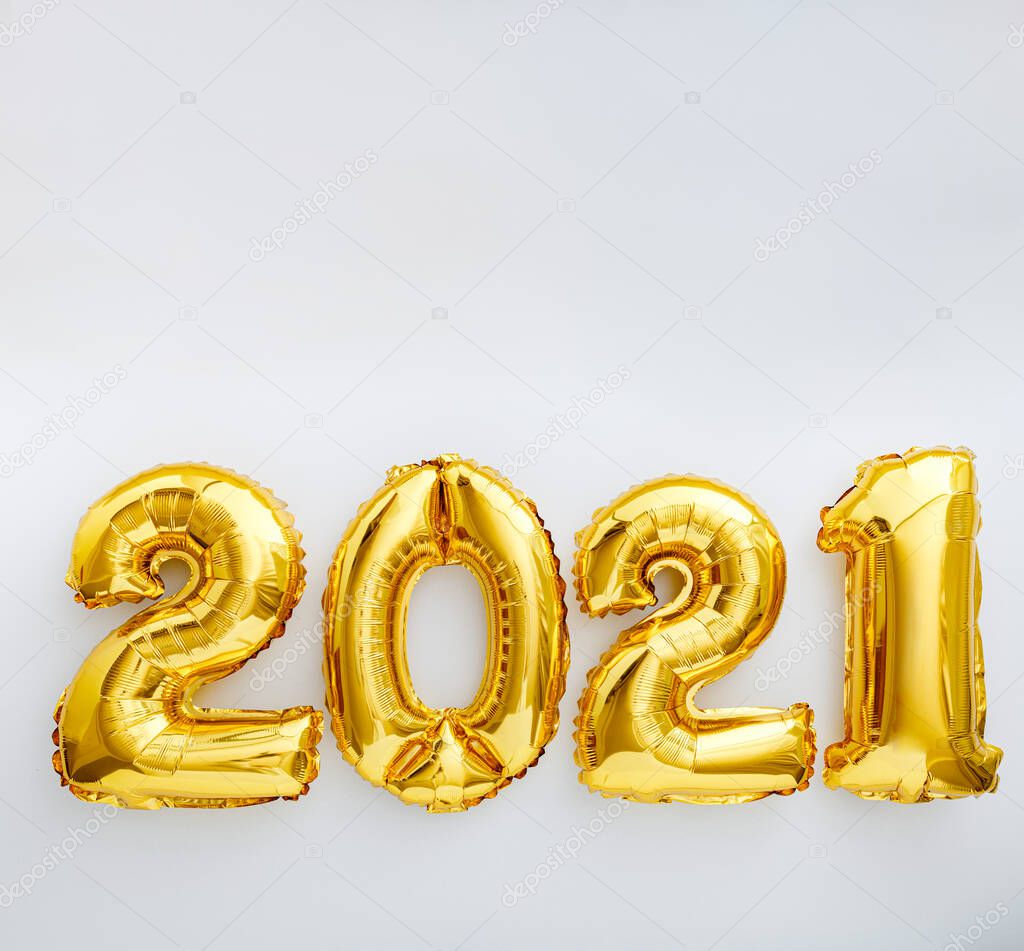 2021 balloon text on white background. Happy New year eve invitation with Christmas gold foil balloons 2021. Square flat lay with copy space.