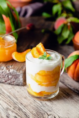 Şeftalili, şeftalili, şeftalili, şeftalili, şeftali reçelli cam bardakta şeftalili tatlı. Meyveli ev yapımı tatlı. Yoğurtlu veya ekşi kremalı meyve salatası.