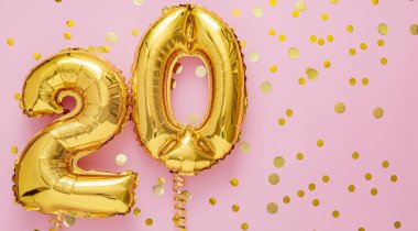 Pembe arka planda 20 hava balonu numarası. Konfetili 20 bin altın folyo. Doğum günü partisi dairesi, kopyalama alanı uzun web pankartıyla yatıyordu