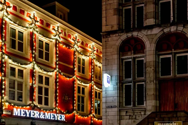 Maastricht, PAYS-BAS - 25 décembre 2019 Décorations urbaines de façade de Noël. Guirlande de Noël s'allume sur la maison fenêtre. Eclairage festif des rues de la ville. Décor du Nouvel An. Millésime européen — Photo