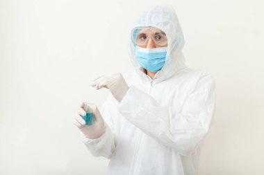 Covid19 aşısı doktorların elinde. Koruyucu giysili doktor, biyolojik tehlike, beyaz arka planda tıbbi maske eldivenleri. Coronavirus aşısı Boşluğu Kopyala