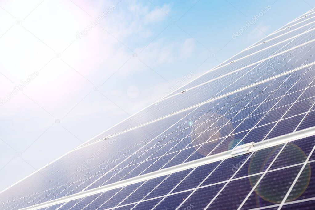 Solar panels on house roof against blue sky. Solar energy power. Sun electricity technology. Stock photo solar panels as a background with sunbeams in sunny day
