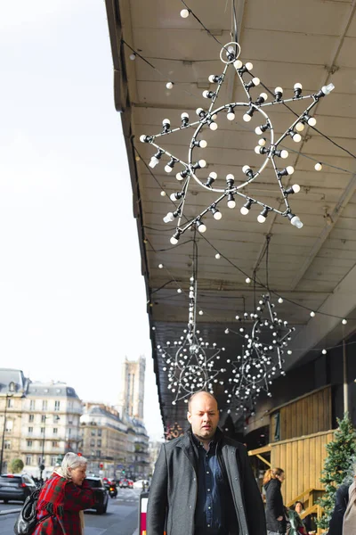 Paris France 21 12 2019 Personnes Passagers dans les rues de Paris pendant le Nouvel An et les vacances de Noël. Façade de maisons décorées avec une étoile faite de lampes. Rue avec décorations de Noël. — Photo