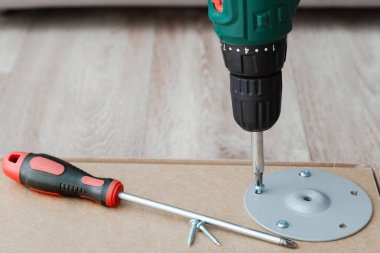 Matkap tornavida ve vida. Mobilya masası montajı. Marangozluk ve ahşap işçiliği için profesyonel ev yenileme araçları