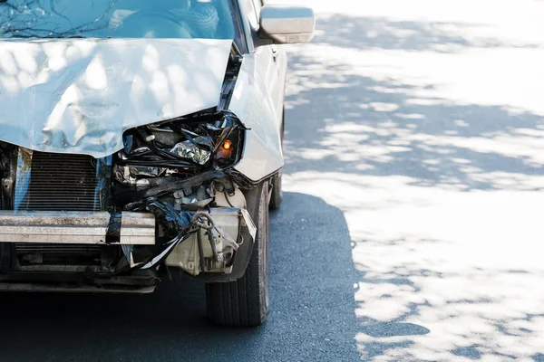 Sérült ittas vezetés összetörte a kocsit. Autóbaleset a városi úton. Összetört elülső fényszóró, behorpadt motorháztető lökhárító nélkül a szürke autón. Gépjármű-felelősségbiztosítás. — Stock Fotó