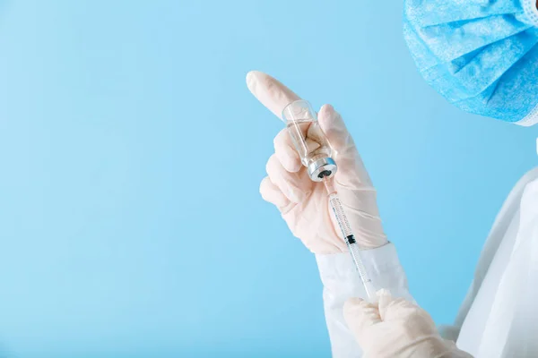 Médecin faisant la vaccination avec un masque protecteur et des gants. Covid 19 Vaccin en flacon en verre et seringue, médicament liquide en main du médecin pour injection. Vaccination et immunisation. — Photo