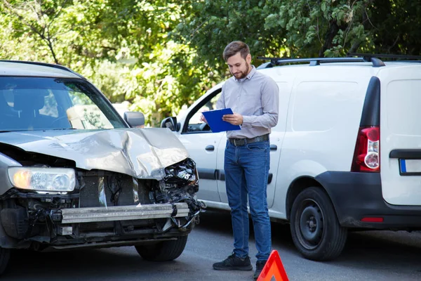 Otomobil sigortası olan bir adam. Trafik kazasında mahvolmuş bir arabaya karşı. Araba kazasında arabanın ön farını kırmış. Otomobil ve sağlık sigortası.