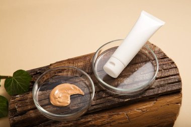 Makyaj malzemesi için doğal nemlendirici krem ve kozmetik laboratuvar vitrininde makyaj ve kozmetik. Kozmetik makyaj ürünleri petri kabında ahşap tahta bej arka planda