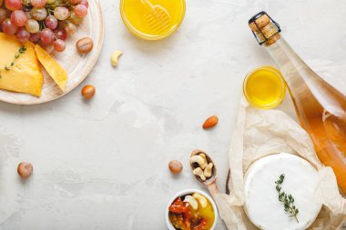 Açık gri kırsal beton arka planda pembe şarap kompozisyonu ve fotokopi alanı. Gül şarabı, peynir ve pembe üzümlerden yapılmış çerçeve, tatlım. Camembert peyniri, şarap barı atıştırmalıkları..