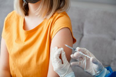Coronavirus covid 19 aşı enjeksiyonu. Hemşire Doktor elinde bir kadına aşı yapıyor. Coronavirus covid 19 'un yayılmasını önlemek için şırınga aşısı enjekte edildi. Tıbbi bağışıklık.