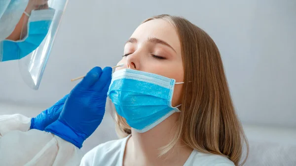 Doktor nazofaringeal kültür alıyor, kadın hastaya PCR testi yapıyor. Hemşire, Coronavirus covid 19 'u kontrol etmek için tükürük örneği aldı. Uzun web pankartı.