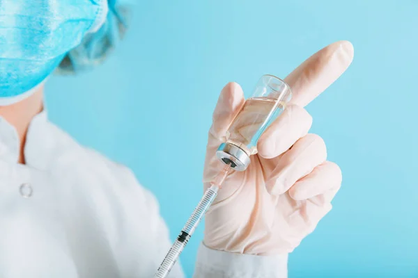 Doctor making vaccination in protective mask and gloves. Covid 19 Vaccine in glass vial bottle and syringe, medicine liquid in doctor hand for injection. Vaccination and immunization