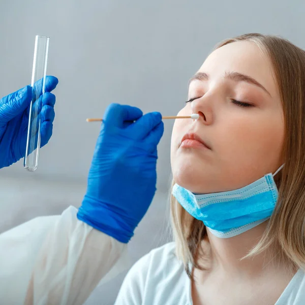 Diagnostics testing patients coronavirus covid. Doctor taking PCR test nasopharyngeal culture to woman patient. Nurse take saliva sample through nose with cotton swab check coronavirus covid 19 test.