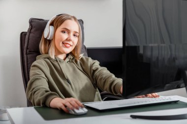 Genç kadın serbest çalışan evden uzakta çalışmakla ya da oturma odasındaki bilgisayar kullanarak oyun oynamakla meşgul. Online eğitim okuyan sıradan bir genç kız. Öğrenci portresi.