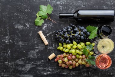 Şarabın farklı çeşitleri ve çeşitleri var. Beyaz pembe ve siyah üzümlerin yanında kırmızı şarap, koyu beton arka planda kırmızı şarap.