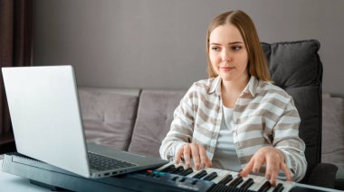 Kadın evde dizüstü bilgisayar kullanarak piyano çalmayı öğreniyor. Kadın öğretmenle çevrimiçi ders sırasında synthesizer piyanoda enstrüman çalıyor. Çevrimiçi konser sanatçısı. Uzun web pankartı