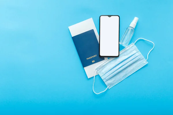 Mockup Smartphone tela em branco passaporte bilhetes de avião máscara médica e desinfetante. Mockup para passe verde aplicativo de teste Covid. Conceito viagem vacinação flat lay na cor azul fundo com espaço de cópia — Fotografia de Stock