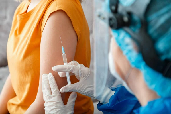 Coronavirus covid 19 vaccine Injection. Nurse in protective medical mask vaccinates woman patient with syringe vaccine in hand. Injection syringe vaccine to prevent spread of coronavirus covid 19