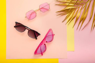 Altın palmiye yapraklı, renkli pembe güneş gözlüğü. Modadan moda optikler, acayip gözlükler, renkli güneş gözlükleri. Üst Görünüm Düz yatıyordu