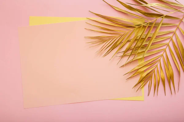 金のヤシの葉で作られたフレーム内のテキストのためのピンクのカードコピースペース。熱帯のヤシはピンクの背景に残る。塗装された金の葉。夏の花の背景. — ストック写真
