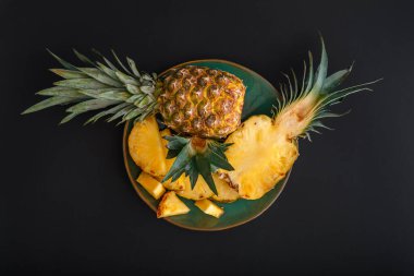 Dilimlenmiş Ananas. Bromelain tüm ananas tropikal yaz meyveleri yeşil tabakta ananas siyah arka plan. Yaz meyveli tatlı Üst Manzara