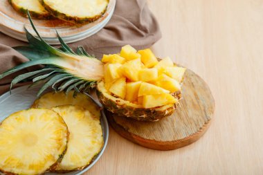 Yarım ananaslı doğranmış ananas salatası. Parçalara ayrılmış taze, lezzetli ananas. Lezzetli bir yaz ananas dilimlenmiş meyve tatlısı ve mutfak masasında malzemeler..