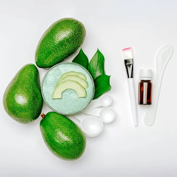 Cilt bakımı ürünleri avokado yağından doğal organik kozmetik ürünleri, beyaz arka planda gerekli yağ. Avokado vücut fırçası ya da yüz maskesi, avokado meyvesinden ev yapımı banyo güzellik ürünleri.