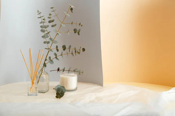 Okaliptüs dalları vazoda buket ve Aromatik ev parfümü çubukları, oda parfümü mumu. Gri sarı ve buruşuk kağıt zemin üzerinde kopya alanı olan ev içi konfor elementi ve aromaterapisi