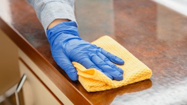 Kadın mutfak tezgahını ıslak bez beziyle siliyor. Kadın temizlikçi el temizleyicisi ofis restoranı yüzeyleri. Uzun web pankartı