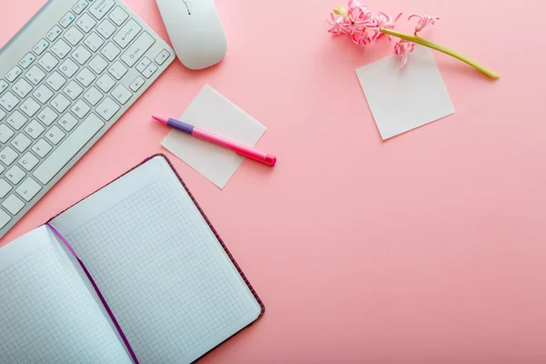 Pink work desk. Work space Office table with computer keyboard and mouse notepad stationery. Top view office table desk with copy space on pink background. Flat lay