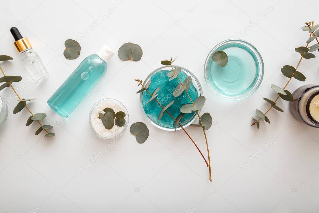 Eucalyptus Gel Serum Natural Cosmetics in Bottle with leaves and branches of eucalyptus plants. Eucalyptus herb oil in skincare cosmetics, alternative medicine aromatherapy white bacground