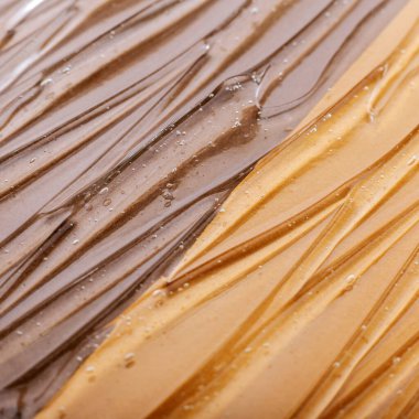 Açık renk ton tonunda Hyaluronic asit jölesi veya kolajen doku. Serum yüzeyi, farklı Afrika ten rengi arka planında nemlendirici ürünün berrak sulu jel dokusu. Kare