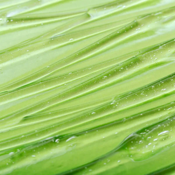 Transparent gel hyaluron serum or Aloe vera on green color background. Water Texture gel surface of cosmetic product for skin health. Sample swatch of chemical gel in laboratory. Close up square
