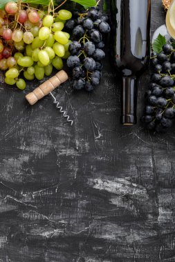 Farklı şarap şişeleri ve siyah arka planda tirbuşon. Taş masanın üzerinde minimalist koyu huysuz kırmızı şarap kompozisyonu. Düz çerçeve