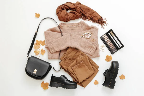 Définir les vêtements d'automne femelle sur fond blanc. Tenue femme élégante en couleur terreuse marron tendance avec sac Accessoires cosmétiques et feuilles d'automne. — Photo