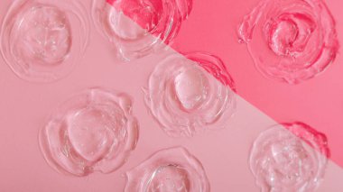 Pembe arka planda şeffaf kumaş kumaşı. Cilt bakımı kozmetik ürün dokusu kolajen ya da hyaluron sıvısı serumu. Cilt bakım jelinden yapılmış çember örnekleri. Uzun web pankartı