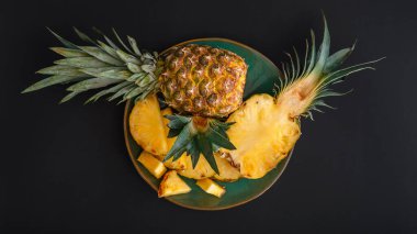 Dilimlenmiş Ananas. Bromelain tüm ananas tropikal yaz meyveleri yeşil tabakta ananas siyah arka plan. Yaz meyveli tatlı Top View. Uzun web pankartı
