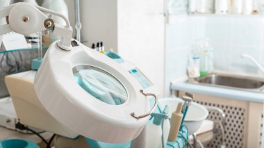 Modern ofis güzellik uzmanı cildiyeci doktor. Profesyonel donanım kozmetolojisinin arkasında estetik kozmetik bilimi için aydınlatma sağlayan tıbbi büyüteç. Uzun web pankartı