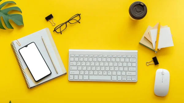 Офис стол стол с компьютером клавиатуры очки, смартфон мышь офис поставляет растения кофе чашки. Плоское офисное рабочее пространство на цветном желтом фоне. Длинный баннер Плоский макет экрана телефона — стоковое фото
