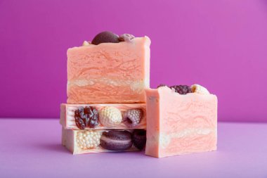 El yapımı pembe sabun bezi. Pek çok zanaatkar pembe sabunları mor arka planda böğürtlenlerle temizler. Doğal cilt bakım ürünleri, banyo ürünleri, ev yapımı tuvalet malzemeleri..