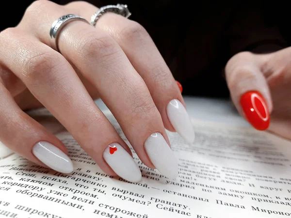 Белые Ногти Красным Дизайном Сердца Фоне Текста Книги Женские Руки — стоковое фото
