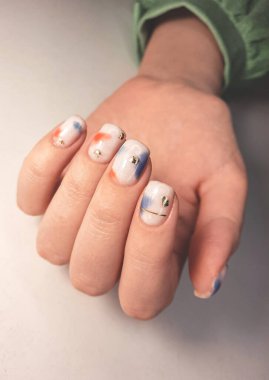 Camouflage gel nail polish with multi-colored design and gold spots. Milky manicure with colored spots. Coating on the nails with geometric patterns and gold. clipart